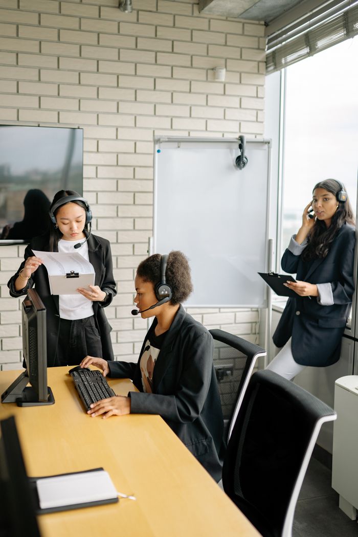 services-02 Three women with headsets working in a call center environment showcasing teamwork and professionalism.
